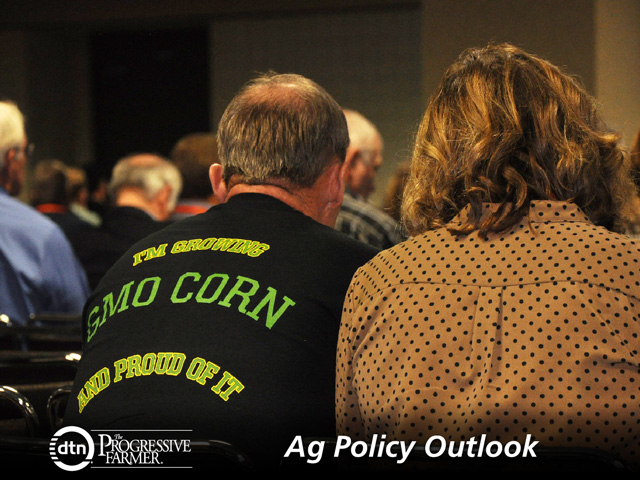 Henry Wunderink of Lowell, Indiana, sports a t-shirt showing his support for growing GMO corn while attending a presentation at the American Farm Bureau annual meeting with his wife, Brenda. Few battles remain more contentious than the consumer debate over labeling foods containing ingredients from biotech products. (DTN photo by Chris Clayton)